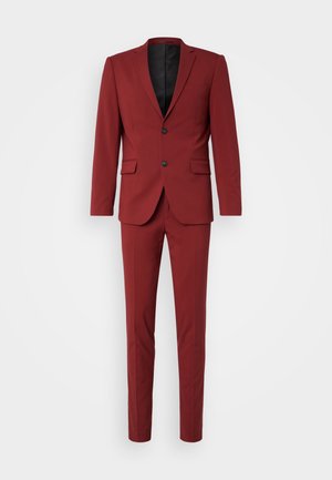 Red suit set featuring a slim-fit design, single-breasted blazer with two buttons, and flat-front trousers. Matte texture, no patterns.