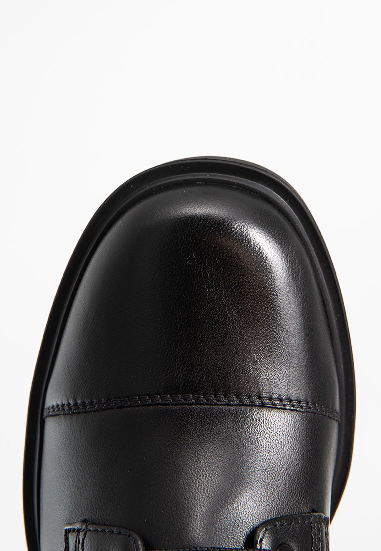 Schwarzer Leder-Schuh mit abgerundetem Zeh, glatter Textur und gesteppten Details. Verfügt über eine flache Sohle und ein minimalistisches Design.