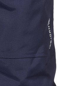 Marinblå tygryggsäck, strukturerad yta, har en söm som är sydd, och en liten vit logotyp på sidan. Kompakt design utan synlig hårdvara.
