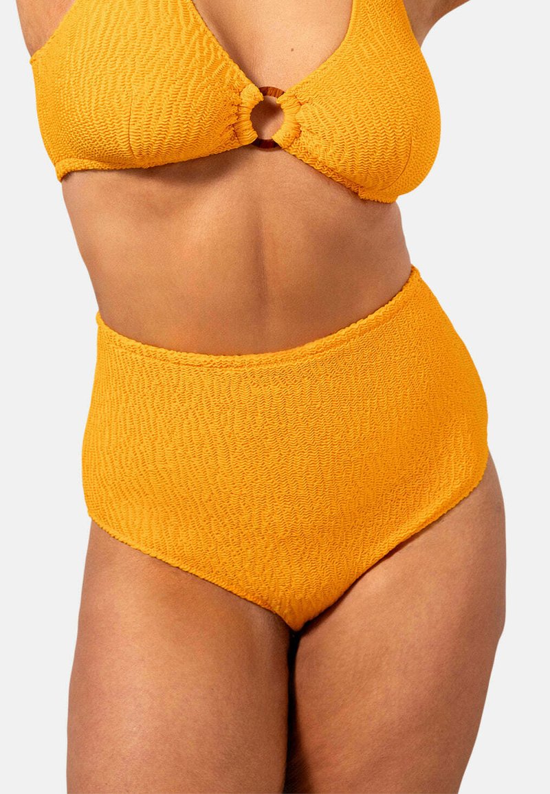 Gul bikiniöverdel med en texturerad, samlad design och en cirkulär brun ringdetalj i mitten; i kombination med en matchande hög midja-bikiniunderdel.