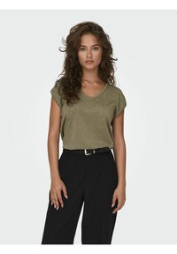 Top corto de manga corta en verde oliva con diseño de escote en V, hecho de un material brillante. Combinado con pantalones negros de cintura alta y un cinturón negro.