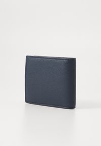 Carteira de couro azul-marinho com acabamento texturizado, design dobrável em duas partes, costuras visíveis e forma retangular e slim.