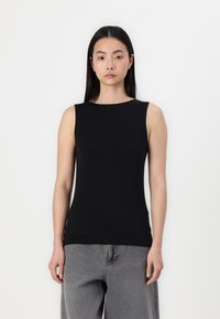 Black sleeveless top with a round neckline, made from smooth, stretchy fabric. Worn with gray wide-leg jeans, minimal design, no visible patterns.
