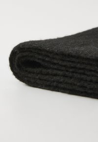 Schwarze Filzdecke, gefaltet mit sichtbarer Textur und geschichtetem Design, zeigt ein weiches, dickes Material und gleichmäßige Kanten.