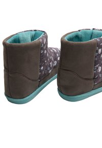 Botines marrones con una superficie suave y texturizada. Forro interior y suela de color azul claro. La parte superior presenta un diseño estampado con varios gráficos pequeños.