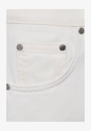 Zbliżenie na białą tkaninę dżinsową, pokazującą małą przednią kieszeń z srebrnymi nitami i szczegółowym przeszyciem.