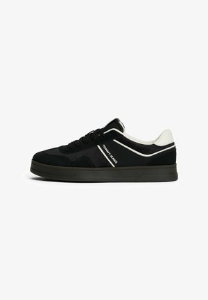 Czarno-białe sneakersy niskie z czarną podeszwą, sznurowadłami i boczną wstawką z logo "Tommy Jeans".