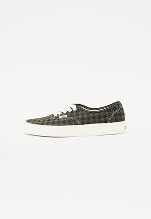 Canvas sneaker featuring a houndstooth pattern in green and black, white rubber sole, and white lace details along the vamp and sides.
