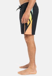 Schwarze Badeshorts mit einem Farbverlauf in Orange, Gelb und Türkis. Mit elastischem Bund und dekorativer Kordel.