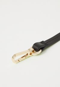 Svart läderrem med en karbinhake i guldmetall. Slät yta med noggrant sömnadsdetaljer.