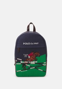 Marinblå tygryggsäck med ridsportmotiv i grönt och bruna läderaccenter, samt text. Dragkedjestängning och dubbla axelremmar.