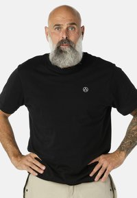 Fekete, rövid ujjú pamut póló. Kicsi fehér logó található a mellrészen. Simább textúrájú, klasszikus kerek nyakkivágással.