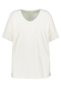 Maglietta bianca a maniche corte con scollo a V, caratterizzata da un motivo texturizzato e un design con cuciture diagonali. Le aperture laterali offrono un ulteriore comfort nei movimenti.