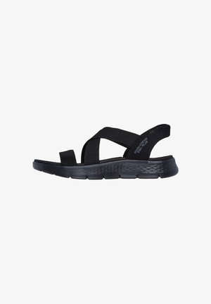 Black sandals with wide fabric straps, open toe design, and molded sole. Textured rubber outsole provides grip and stability.