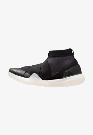Baskets montantes noires avec brides croisées élastiques, tige en maille, semelle blanche amortissante et logo Adidas sur le contrefort du talon.
