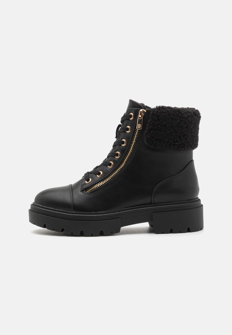 Bottines en cuir noir avec un bout arrondi, des accents dorés, des doubles zips et un revers en fausse fourrure noire. Semelle en caoutchouc épaisse avec traction.