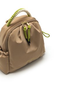 Mochila de nailon beige con un asa trenzada blanca y verde, herrajes dorados en el cierre y acentos negros en los tiradores del cierre.