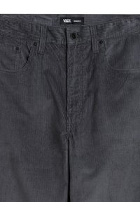 Grijze corduroybroek met verticale ribbelstructuur, vijf-pocketdesign, knoop- en ritssluiting, en merklabel op de tailleband.