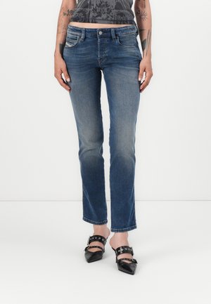 Light blue denim jeans with a straight fit, mid-rise waist, five-pocket design, and faded texture. Paired with black pointed-toe shoes.