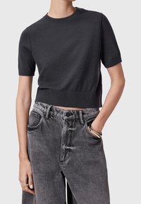 Black short-sleeve cropped sweater made of knit material, paired with high-waisted, faded gray denim jeans with a straight fit and front pockets.