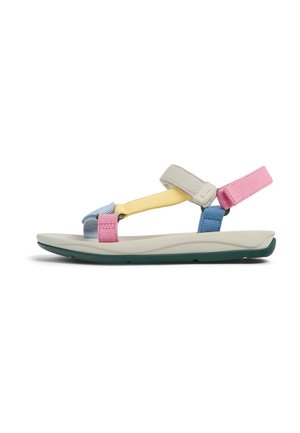 Flad sandal med justerbare remme i pink, blå, gul og beige på en hvid sål med mørkegrøn ydersål, vist i sideprofil.
