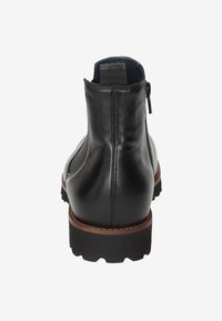 Stivaletto in pelle nera con texture liscia, suola marrone a contrasto, chiusura con zip posteriore e design della punta rotonda.