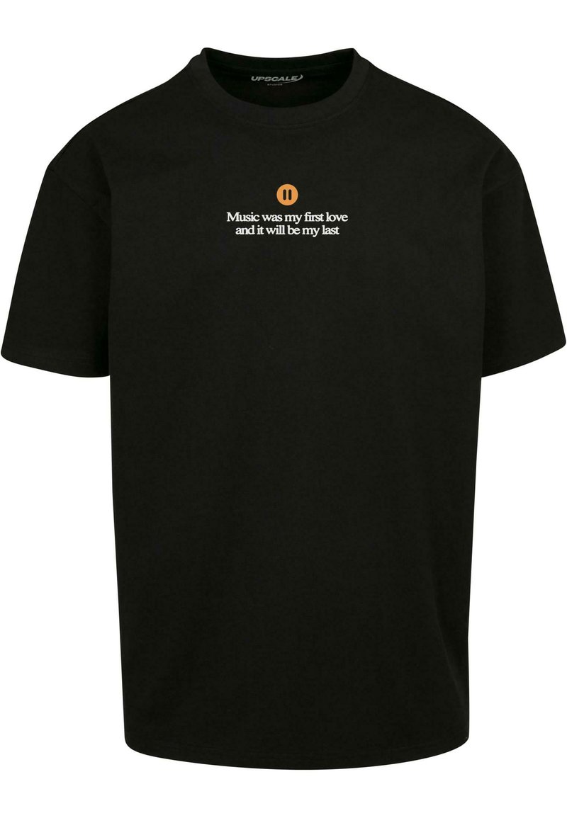 Sort bomulds t-shirt med korte ærmer, der har hvid tekst og et pause symbol. Teksten lyder: "Musik var min første kærlighed, og det vil være min sidste."