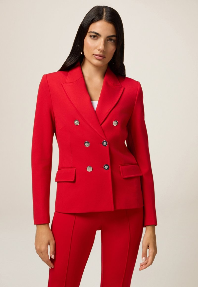 Czerwony żakiet dwurzędowy z srebrnymi guzikami, z wykładanym kołnierzem, dwoma przednimi kieszeniami, dopasowany krój, wykonany z gładkiego materiału.