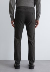 Donkergrijze, gestructureerde broek met een rechte pasvorm, voorzien van twee achterzakken met knopen en een tailleband met geribbelde details.