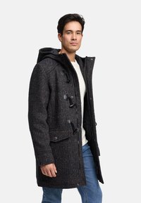 Dark tweed coat with a hood, featuring black toggle fastenings and side pockets, worn over a light sweater and blue jeans.