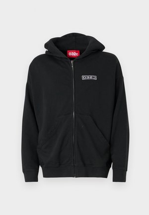 Sort zip-up hoodie lavet af blødt stof med en frontlomme. Har en hætte og et broderet logo på brystet.