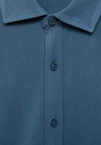 Polo shirt blu con texture, colletto e tre bottoni blu scuro sul davanti.