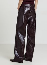 Bordeauxrote, hoch taillierte, weit geschnittene Hose aus glänzendem, strukturiertem, lederähnlichem Material mit sichtbaren Nähten und Taschen.