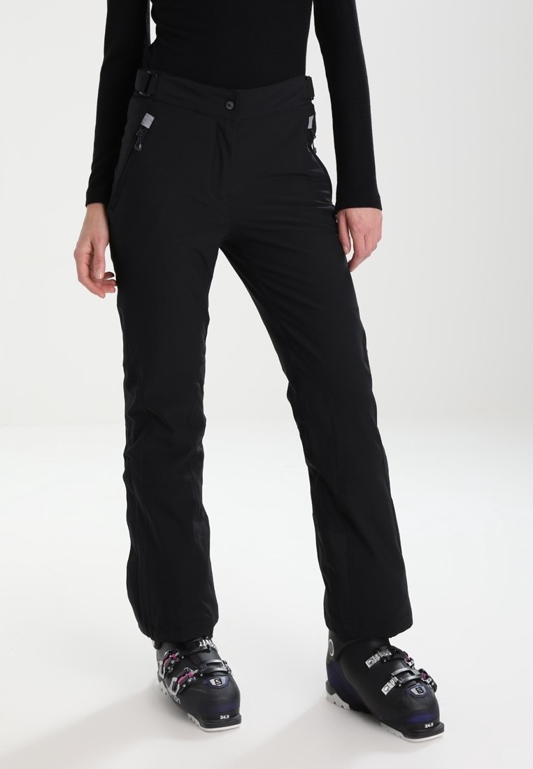 Pantalones de esquí impermeables negros con corte recto, cintura ajustable y bolsillos con cremallera, combinados con botas de esquí negras con detalles en rosa.