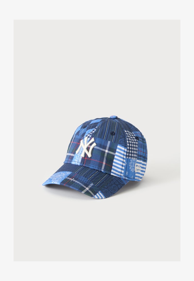 Casquette de baseball patchwork bleue avec le logo blanc des New York Yankees brodé sur le devant et divers motifs à carreaux et rayures.