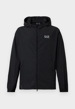 Fekete, kapucnis, cipzáros dzseki rugalmas mandzsettákkal és EA7 Emporio Armani logóval a mellkason, fehér háttéren bemutatva.