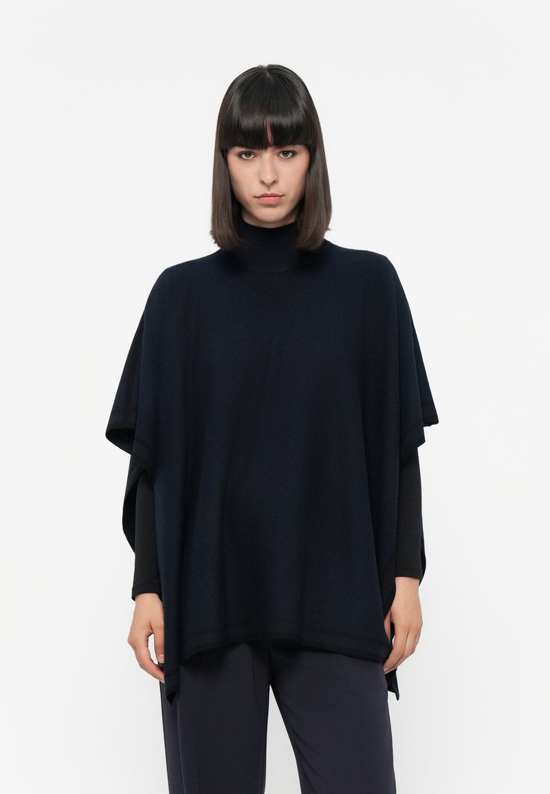 Poncho di un navy scuro realizzato in tessuto morbido, con un alto collo, vestibilità ampia e maniche larghe. Nessun motivo visibile o dettagli hardware.