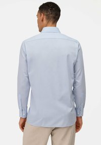 Lichtblauw overhemd met lange mouwen en een button-down kraag, met een gladde textuur en manchetten met één knoop. Rechte zoom en detail op de achterzijde.