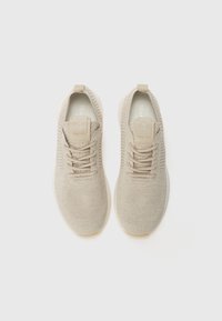 Lys beige sneakers laget av strikket stoff, med en teksturert overdel, snøring og løkker på hælen for enkel påkledning.