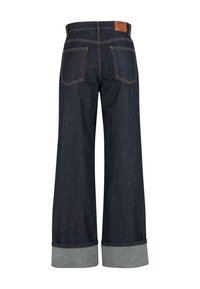 Tamsiai mėlynos plačios džinsinės kelnės su apvyniotais kraštais, dviem galinėmis kišenėmis, kontrastinėmis siūlėmis ir mažo išsiuvinėjimo detale dešinėje kišenėje.