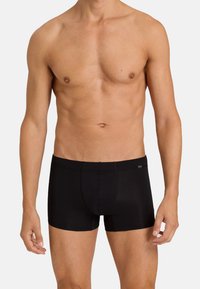 Black boxer briefs made of smooth fabric with a snug fit. Features a short leg design and subtle branding on the waistband.