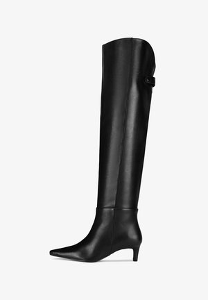 Botas negras por encima de la rodilla hechas de cuero liso. Presentan una puntera puntiaguda y un tacón bajo y cónico con un detalle de botón en el lateral superior.