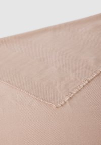 Tkanina w kolorze brzoskwiniowym z subtelnym wzorem w jodełkę i postrzępionymi krawędziami, prezentująca miękką teksturę z gładkim wykończeniem.