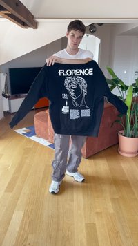 Svart hettegenser med hvitt grafisk design av en klassisk statue, merket "FLORENCE" og "1501" med tekstdetaljer, avslappet passform.