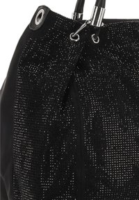 Bolso negro con superficie texturizada con pequeños remaches reflectantes, detalles de metal y asas dobles para llevar.