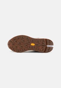 Rubber shoe sole with deep, aggressive tread pattern. Brown color features pronounced arrow shapes for traction. Durable and textured surface.