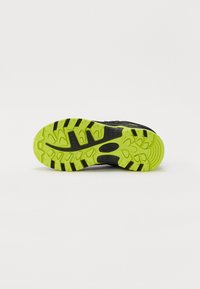 Sort atletisk skosål med en lys grøn gummidækning, der har udtalt grebsmønstre og teksturerede detaljer for bedre traction.
