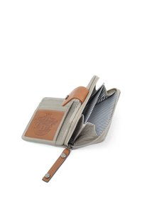 Beige portemonnee met leren accenten, ritssluiting, gestreepte binnenkant, kaartvakken en reliëflogo. Heeft een drukknopsluiting en lus.