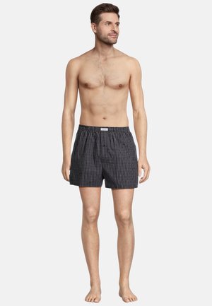 Shorts de boxeur à carreaux noir et blanc avec une taille élastique et un braguette à un seul bouton, fabriqués en tissu léger.