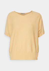 Krótki rękaw, top z dekoltem w serek wykonany z miękkiej, jasnożółtej tkaniny o luźnym kroju i prążkowanym obszyciu. Gładka tekstura, bez wzorów i dodatków.